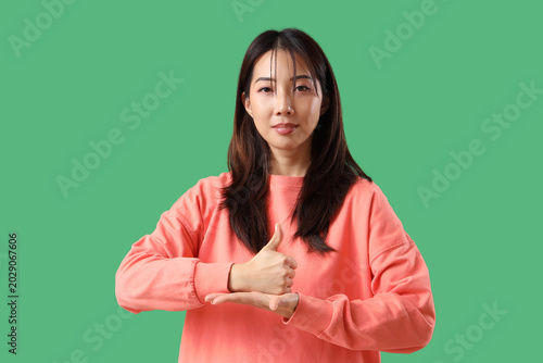 Young happy Asian woman usi...