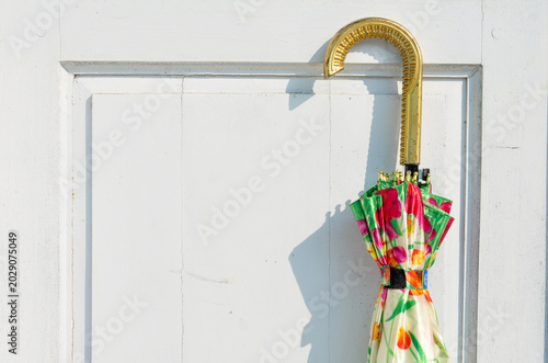 Colorful Umbrella Hanging on White Door
