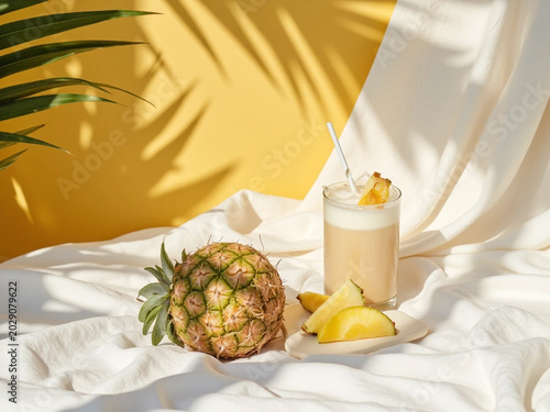 Fresh pineapple and citrus drink on white cloth outdoors in sunlight