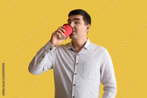 Happy young man drinking co...