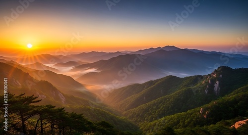 Mountains stand tall under a radiant golden sunrise in the morning.