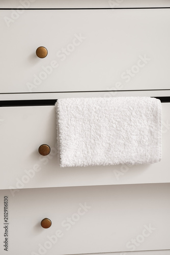 Schilderij op canvas White chest of drawers with towel, closeup