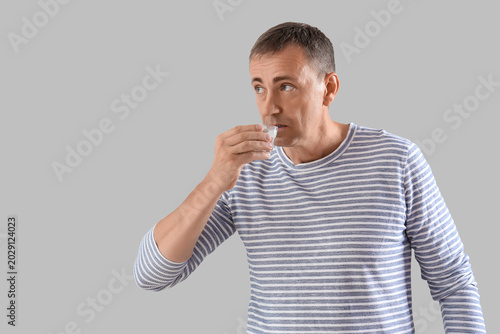 Mature man drinking vodka o...