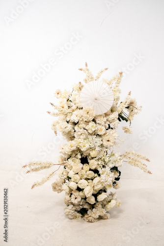 Detail with white japanese vibe umbrela, Elegant white flowers cascade upward in graceful tiers. Delicate blooms and soft petals frame a clean, minimalist backdrop. Neutral tones enhance purity
