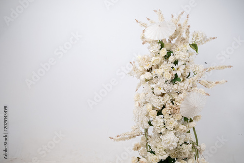 Detail with white japanese vibe umbrela, Elegant white flowers cascade upward in graceful tiers. Delicate blooms and soft petals frame a clean, minimalist backdrop. Neutral tones enhance purity