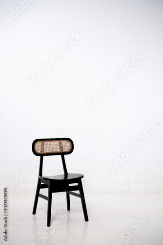 Warm wooden chairs with woven cane backs. Curved seats and slender legs create elegant design. Simple, minimalist style suits modern interiors. Ideal for cafes, homes, or cozy dining spaces.