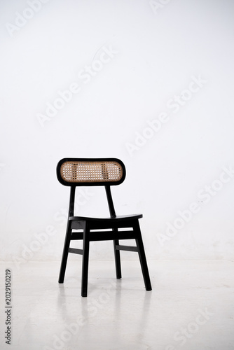 Warm wooden chairs with woven cane backs. Curved seats and slender legs create elegant design. Simple, minimalist style suits modern interiors. Ideal for cafes, homes, or cozy dining spaces.