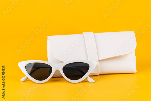 Fotografie Sunglasses, fashion eyewear, and a glasses case against a yellow background