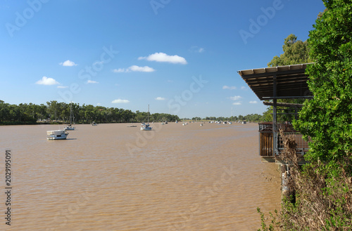 Boats and yachts anchored on the wide, brown waters of the Fitzroy River in Rockhampton, Queensland, Australia
