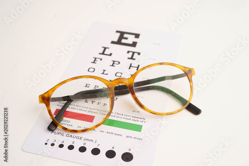 Foto Glasses on eye testing exam chart to check eyesight accuracy of reading