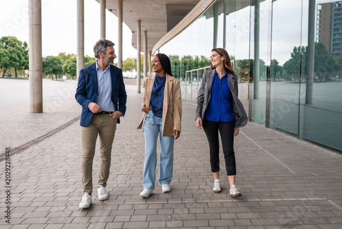 Business professionals walking and having a conversation outdoors