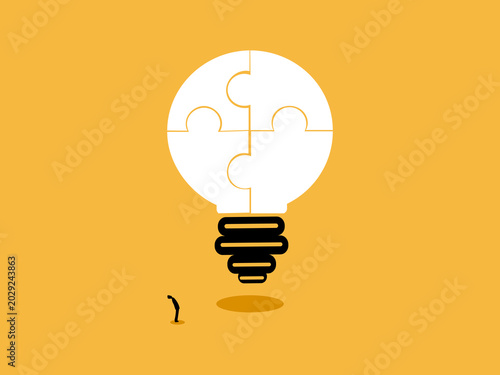 Foto businessman stood gazing at the completed jigsaw puzzle light bulb