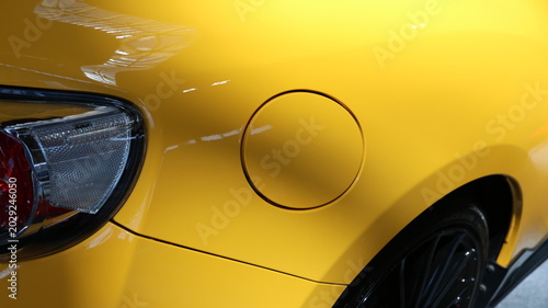 Slika na platnu Close up of a bright yellow car fuel filler door and rear taillight