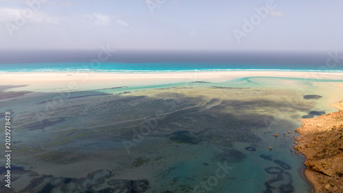 Foto Aerial turquoise lagoon with sandbars and deep blue ocean