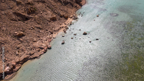 Fotografia Aerial Rocky Desert Coastline With Shallow Clear Water