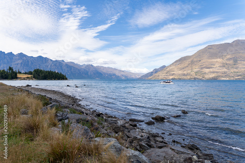 Majestic alpine mountains rise above the calm waters of Lake Wakatipu
