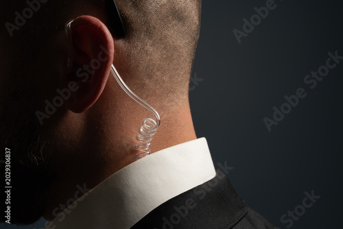 Photography Close up of security guard or secret service agent wearing transparent acoustic