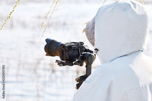 Photos Cameraman using handheld camera gimbal stabilizer for outdoor video shooting