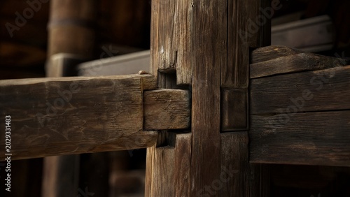 Ancient wooden beam with mortise and tenon joint, detailed texture.