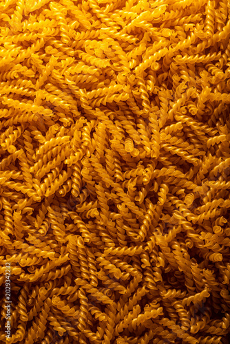 pasta spirals made at the factory top view, macro, background, yellow