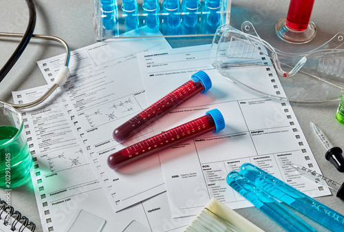 Blood sample tubes on medical patient forms, healthcare laboratory testing and diagnostic analysis concept