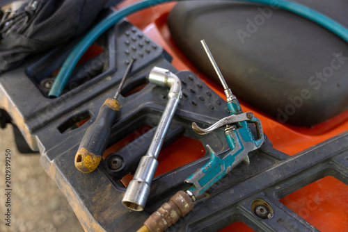 Quadro su tela Mechanic tools including screwdriver wrench air blow gun lying on orange machine