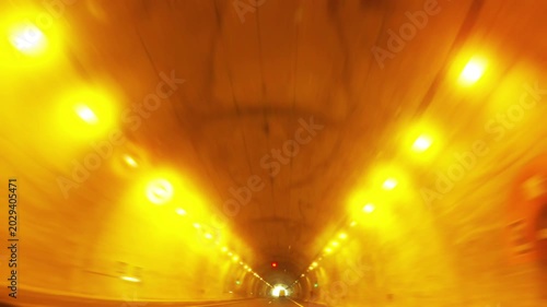Driving through a dimly lit urban tunnel with yellow lights