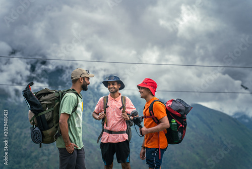Fotografie Three hikers with backpacks talking during a mountain trek at Ali Bedni Bugyal,