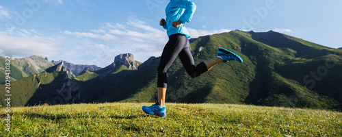 Trail runner running  on the high altitude grassland mountain top