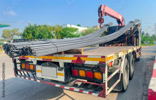 Truck transporting steel rebar and round steel bars for construction industry, heavy industrial logistics and building materials delivery.