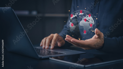 Fotografía Businessman holding digital globe with red location pins for global network connection