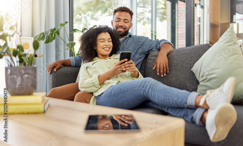 Obraz na plátne Smile, black couple and relax with phone at house for social media, browsing website and bonding