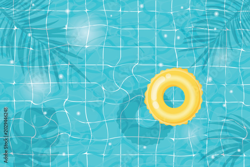 Yellow inflatable swimming ring floating in pool blue tiled bottom and palm leaf shadows summer resort, poolside relaxation and vacation concept
