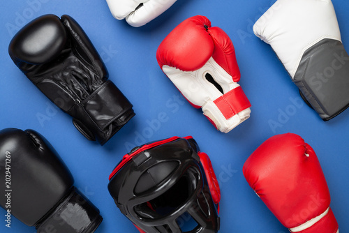 Slika na platnu Boxing helmet and gloves on color background, top view.