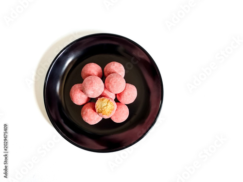Fényképezés Pink strawberry boule de neige cookies stacked on black round plate, isolated on white background