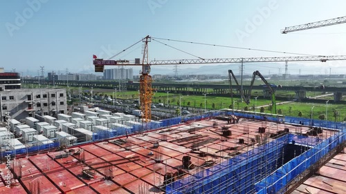 Tower crane and steel reinforcement bars on a construction site under blue sky