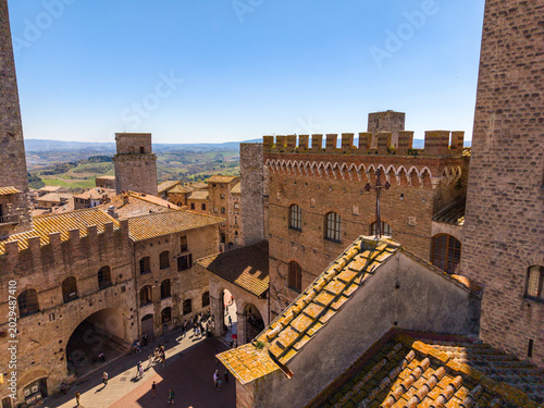 Obraz na plátně View across the rooftops and towers of San Gimignano, showing the compact medieval town set against the Tuscan landscape