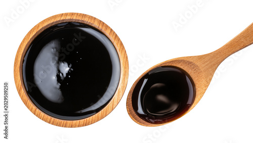 Photos Dark viscous liquid in wooden bowl and spoon