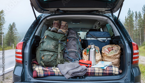 Open car trunk packed chaotically for camping