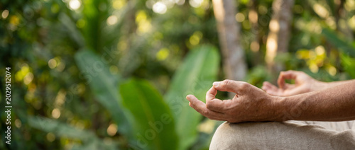 Man Meditating in Yoga Mudra Pose in Tropical Nature Background