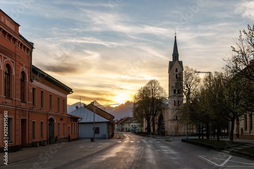 Принти на полотні Tall church spire and town buildings at sunset