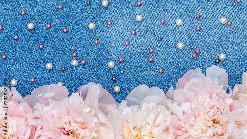 Obraz premium Flowers and beads arranged on denim fabric create a colorful display for craft projects