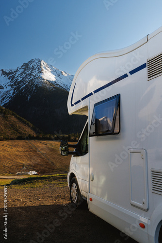 White Camper Van Parked In Snowy Mountains