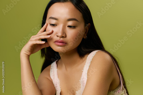 Charming young asian woman embodies elegance in fashionable summer studio setting