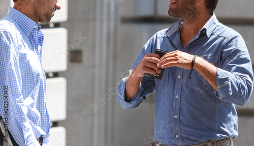 Two Casual Businessmen Talking and Networking on a Sunny City Street