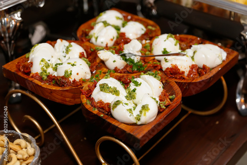 Creamy buffalo burrata cheese over sun dried confit tomatoes with fresh pesto sauce