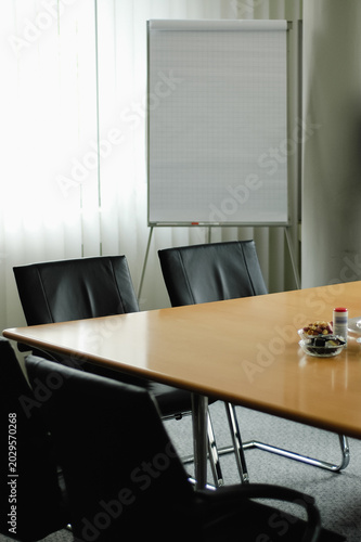 Empty conference room in hotel for business meeting with wooden table and vertical blinds during day, meeting or syndicate room in office building or lawyers office