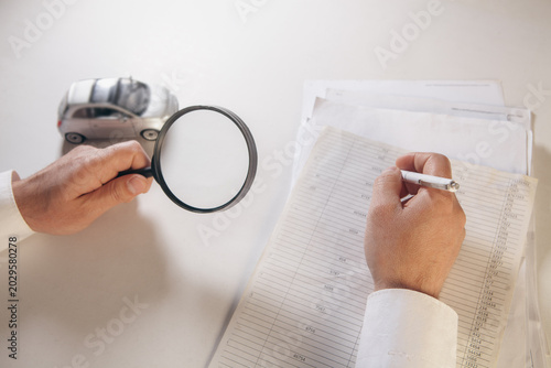 Bilde på lerret A man examines the car cataract with a magnifying glass.