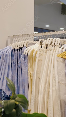 Organized collection of casual pastel tops. Colorful lightweight shirts neatly arranged on clothing rack. Selection of soft pastel cotton shirts meticulously hung for daily casual style
