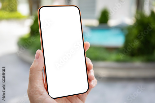 Man hand holding phone orange blank white screen mockup outdoors